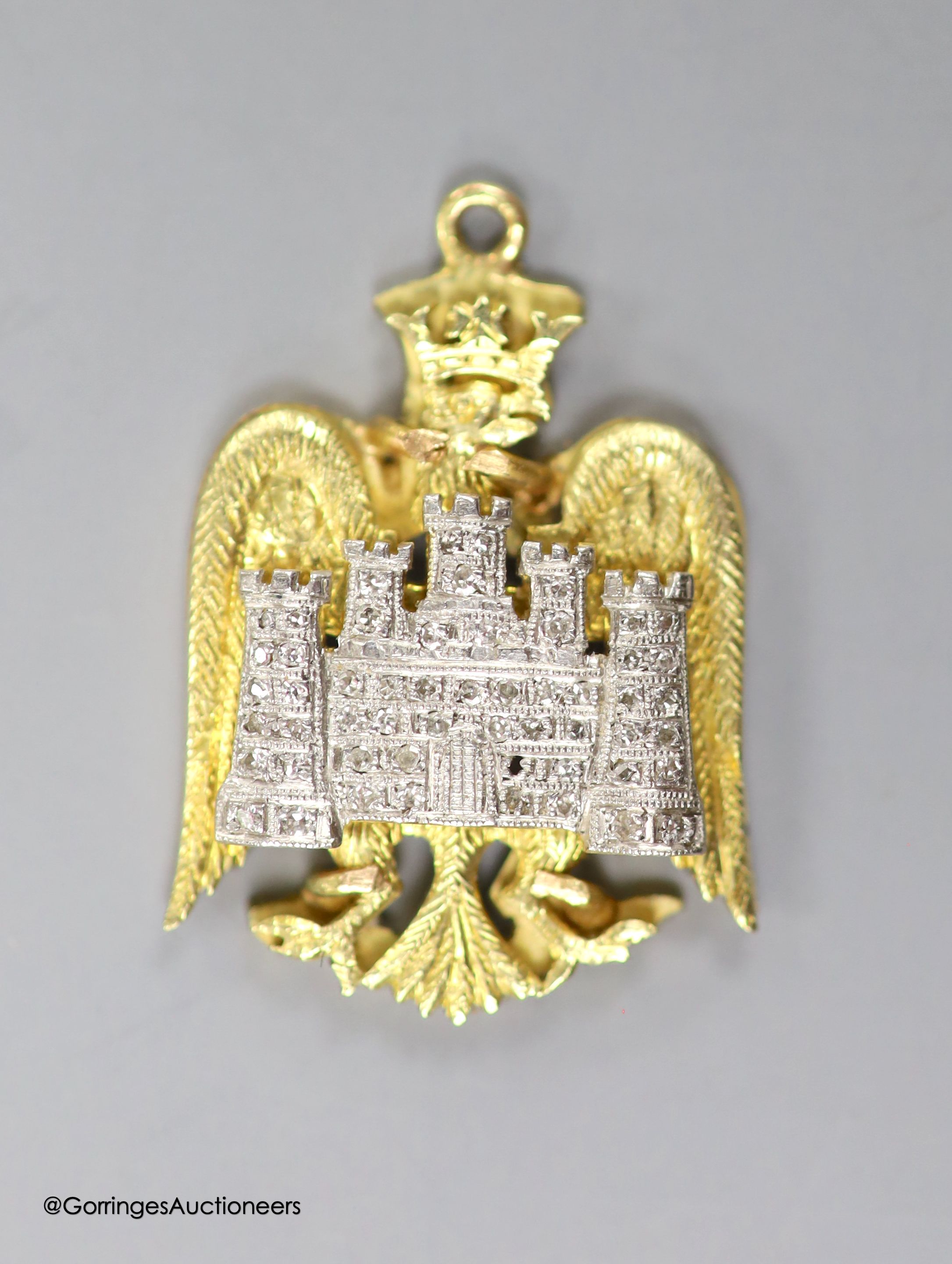 A 14ct, plat and diamond chip set 'eagle and castle' pendant, 27mm, gross weight 7.2 grams.